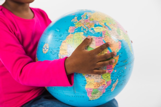 Child holding globe in studio