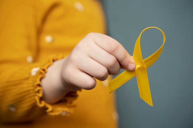 Child holding yellow ribbon