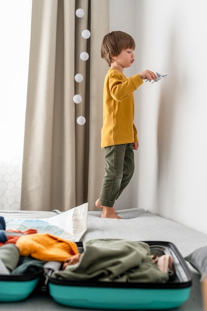 Child at homer with luggage and airplane figurine