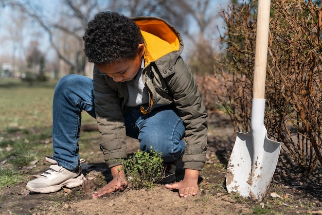 Child learning how to plant a tree