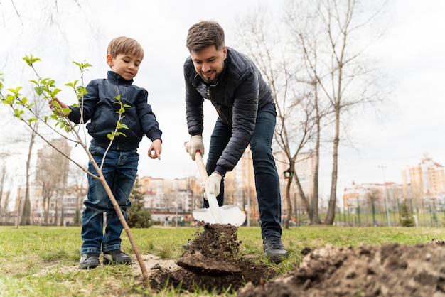 Free photo child learning how to plant a tree