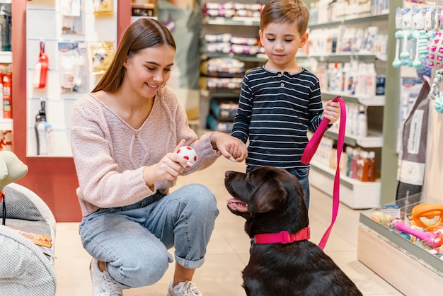 Free Photo child and mother at the pet shop with their dog