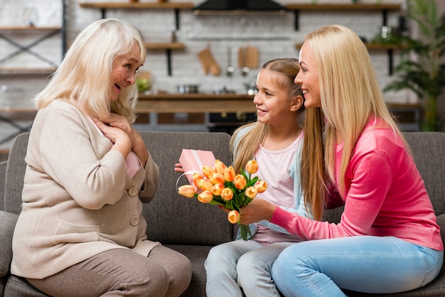 Child offers bouquet of flowers to her grandma