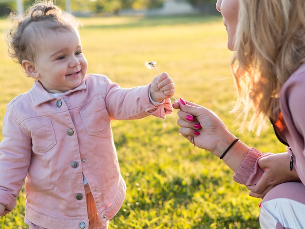 Free photo child in pink clothes holding a flower