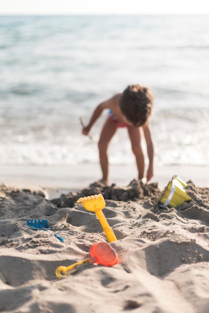 Free photo child playing at the beach with toys