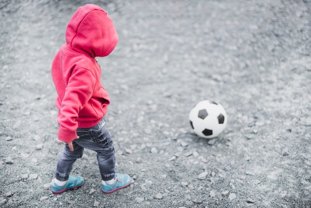 Child playing outside with football