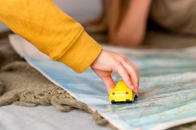 Free photo child playing with car toy on map