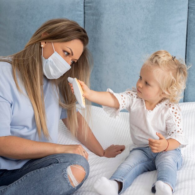 Child playing with thermometer next to mom