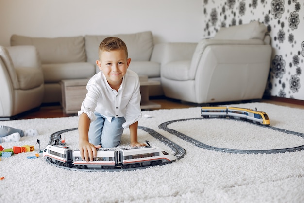 Free photo child playing with toy train in a playing room