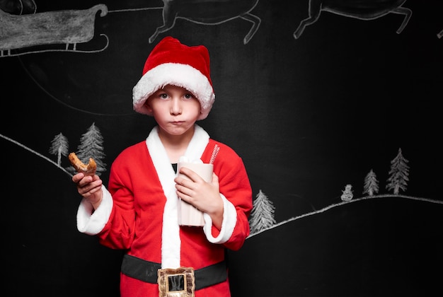 Free Photo child in santa claus costume eating gingerbread