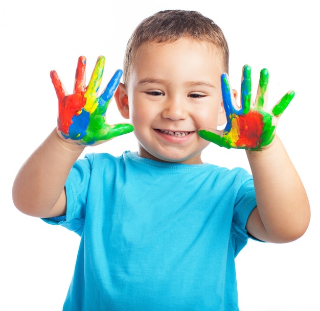 Child smiling with hands full of paint