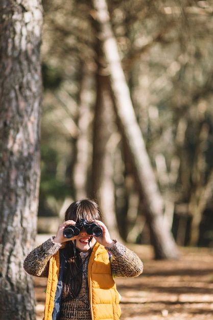 Free photo child with binoculars in woods