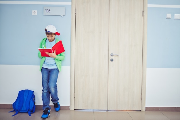 Child with cap doing his homework