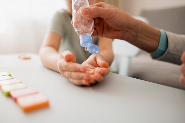 Child with hand sanitizer at home before class