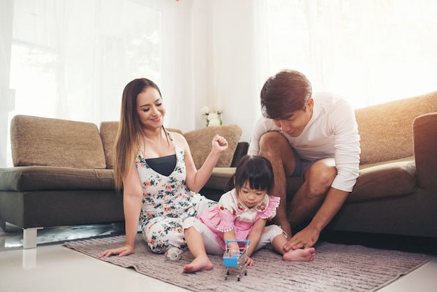 Child with her parent playing on floor in living room