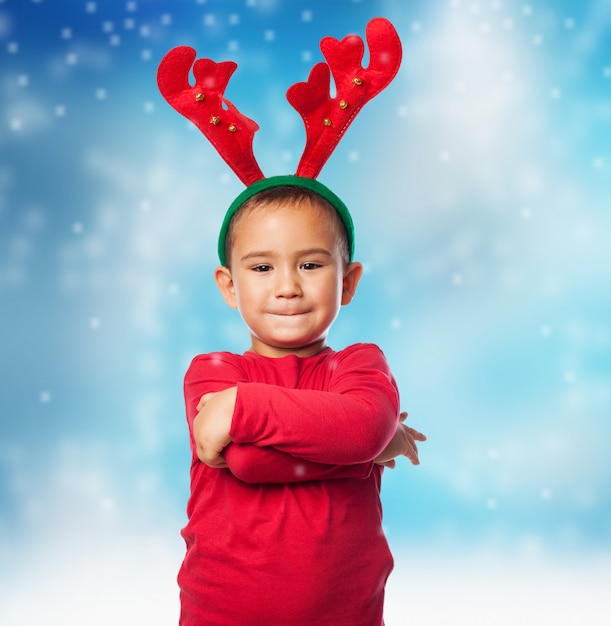 Free Photo child with plush reindeer antlers in snow background