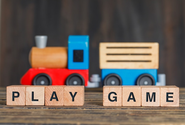 Free Photo childhood and activity concept with toy train, wooden cubes on wooden table side view.