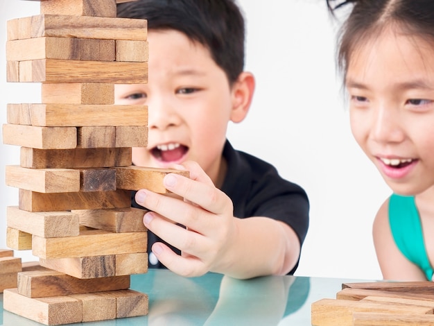 Children are playing jenga, a wood blocks tower game