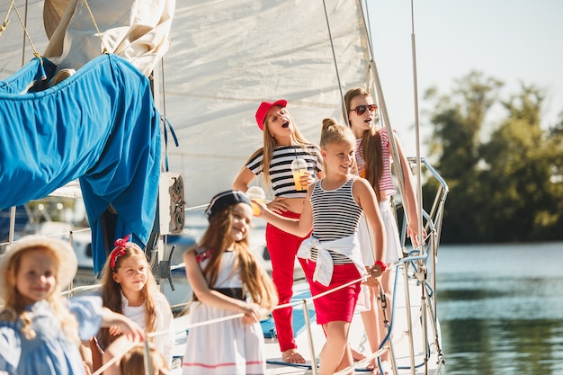 Free Photo children on board of sea yacht drinking orange juice.