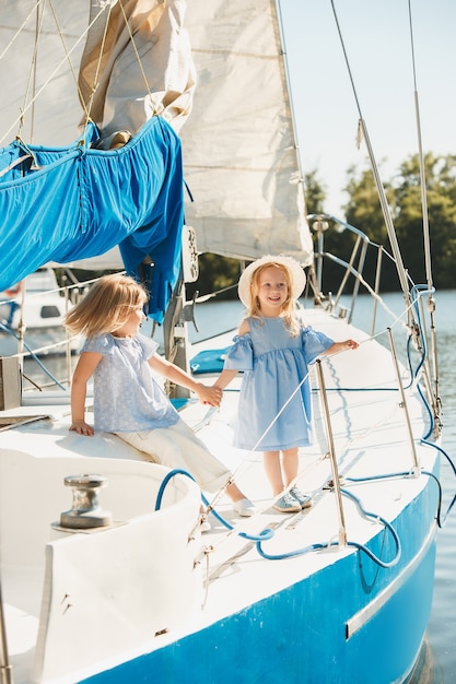 Free Photo the children on board of sea yacht. the teen or child girls outdoor. colorful clothes. kids fashion, sunny summer, river and holidays concepts.