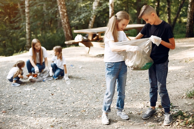 Free photo children collects garbage in garbage bags in park