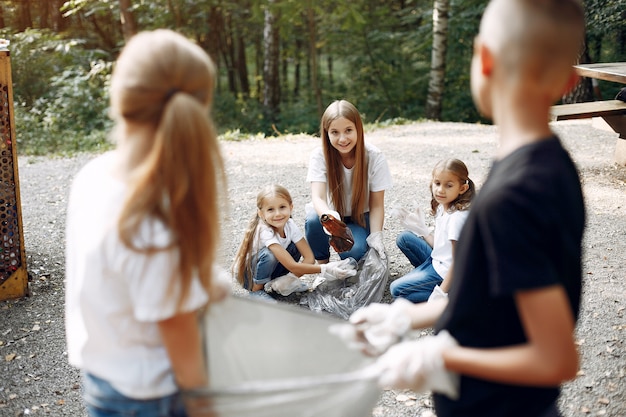 Children collects garbage in garbage bags in park