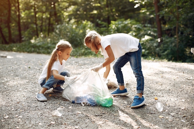 Free photo children collects garbage in garbage bags in park