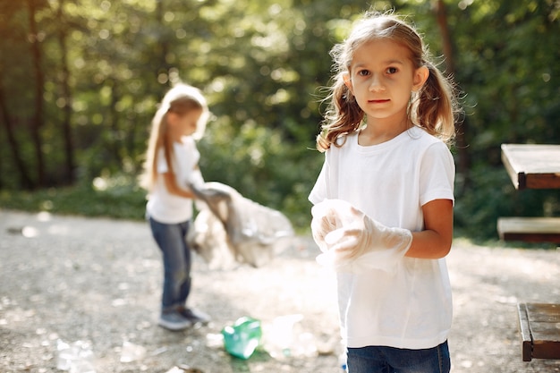 Free photo children collects garbage in garbage bags in park