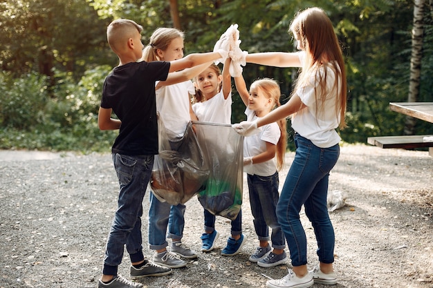 Children collects garbage in garbage bags in park