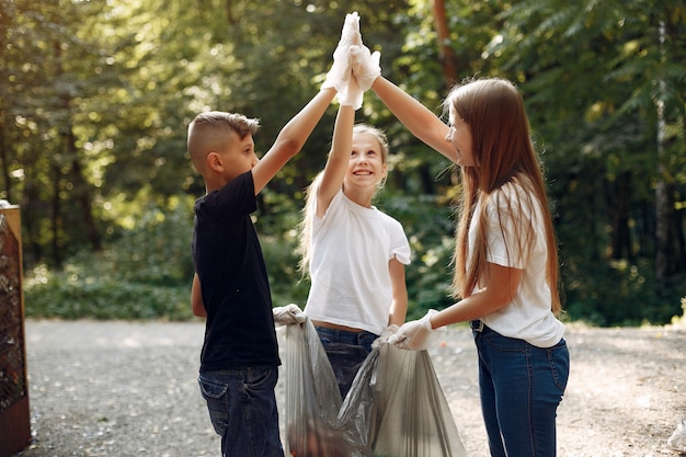 Free photo children collects garbage in garbage bags in park