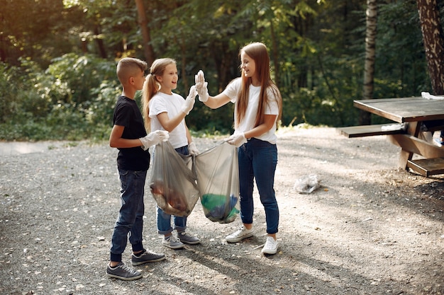 Children collects garbage in garbage bags in park