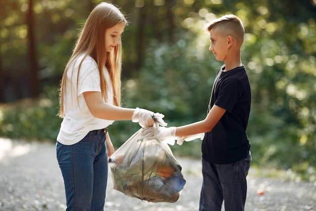 Free photo children collects garbage in garbage bags in park