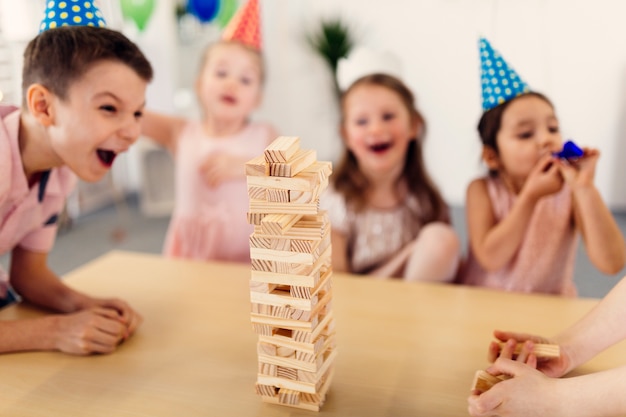 Children in colored caps laughing on party