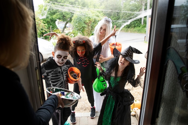 Free photo children in costumes trick or treating on halloween