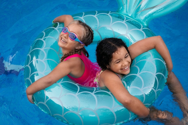 Children having fun with floater at the pool