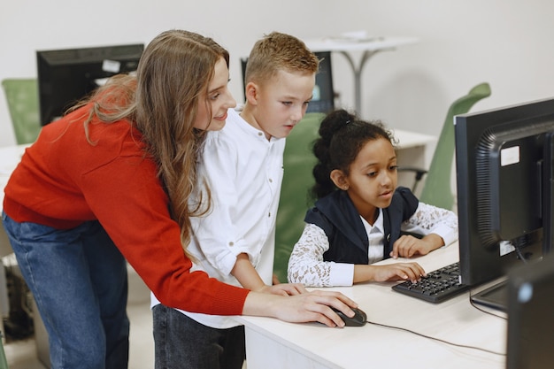 Children learns to work on a computer. African girl  sitting at the table. Boy and girl in computer science class.