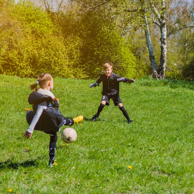 Free photo children playing soccer on a sunny day