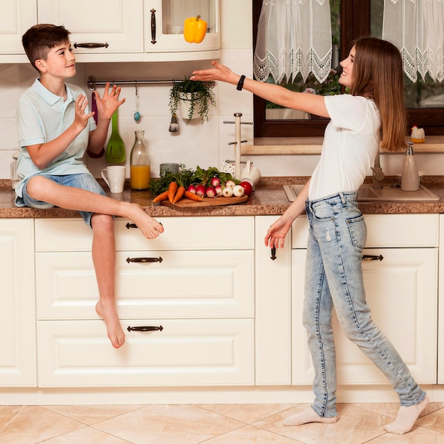 Children playing with vegetable in the kitchen