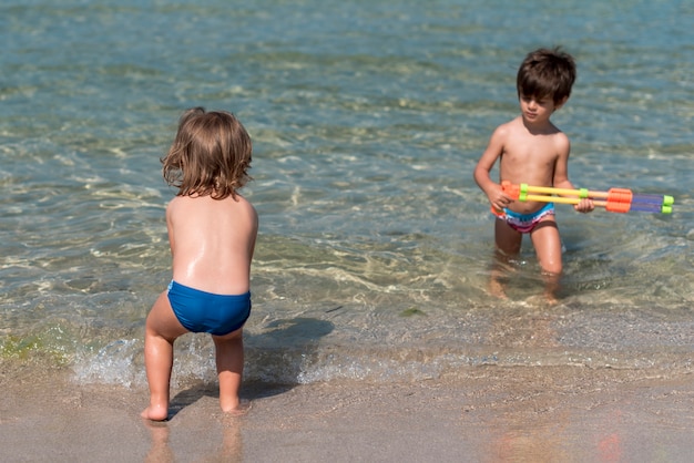 Children playing with water guns at the beach