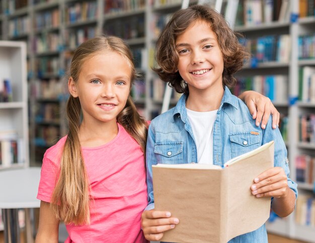 Children reading a book together in the library