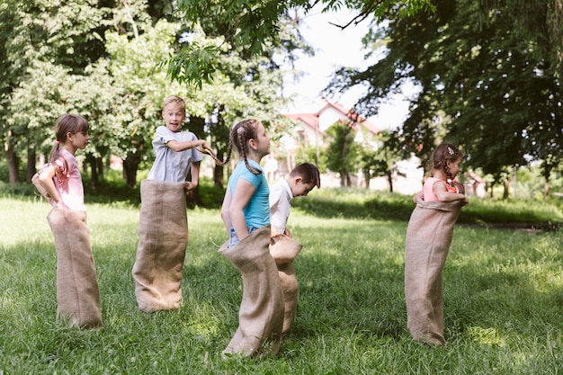 Free Photo children running in burlap bags