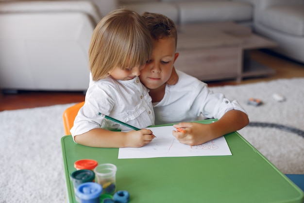 Free photo children siting at the green table and drawing