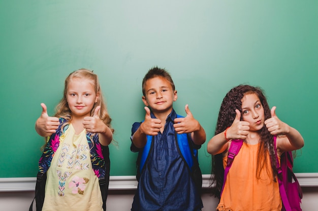 Free photo children standing with thumbs up