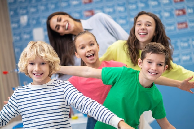 Free Photo children and teacher in playful mood smiling at camera