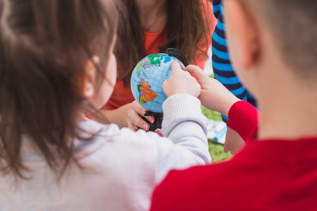 Free Photo children watching and touching globe