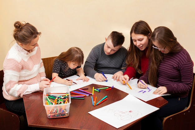 Free photo children with down syndrome drawing together