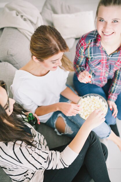 Chilling girlfriends having popcorn and beer