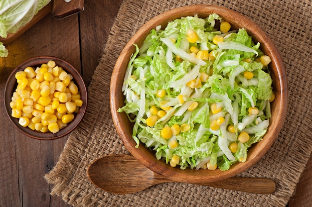 Chinese cabbage salad with sweet corn in a wooden bowl