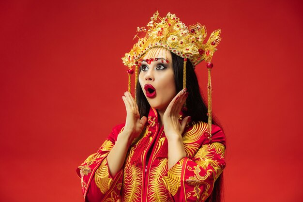 Chinese traditional graceful woman at studio over red wall