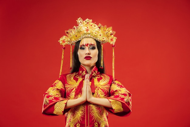 Free Photo chinese traditional graceful woman at studio over red wall